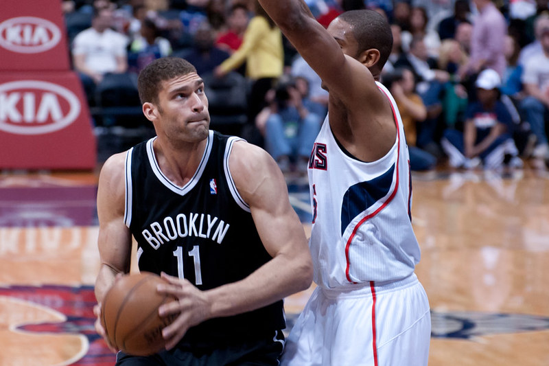 Brook Lopez defending against an opponent with his signature shot-Blocking stance.